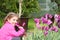 Little girl smell tulip flower