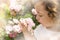 Little girl smelling flower on blurred hazy background