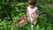 Little girl smelling flower in the garden