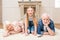 Little girl with smiling grandpa and grandma resting together at home