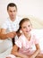 Little girl is smiling while her father is braiding daughter`s hair