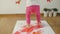 Little girl with smudgy paint fingers draws on a large sheet of white paper sitting on the floor