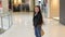 A little girl is spinning with packages in her hands in a trendy shopping Mall.