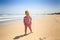 Little Girl in Spotty Stands Looks at Glove by Wave Surf