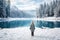 little girl stand in front of blue frozen lake in winter