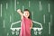 Little girl standing against chalkboard and airplane  icon on the board