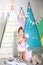 Little girl standing with balloon is home. Child is playing in his children bedroom with colorful wigwam, toys and pencils. Concep