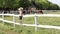 Little girl standing on corral