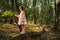 Little girl standing in the forest with ferns