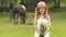 Little girl is standing in a park with a bouquet of wildflowers. Slow motion