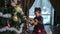 Little girl stands near the Christmas tree.