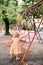 Little girl stands near a ladder with round holes on a playground