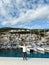 Little girl stands on the pier against the backdrop of moored yachts