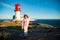 Little girl stands on rocky northern seashore