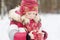 Little girl stands in winter park warming artificial bird