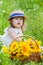 Little girl in a straw hat and a basket of sunflowers