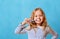 A little girl in striped pajamas is brushing her teeth with a toothbrush. The concept of daily hygiene.