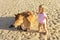 A little girl stroking a stray cow that lies on the sand of the beach, a stray animal, love for living creatures,