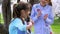 Little girl strums on guitar while her girlfriend standing clapping his hands listening music. wonderful spring day into