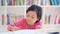 Little girl studying on the table in library