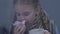 Little girl suffering flu symptoms, drinking hot tea and sneezing, epidemics