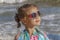 Little girl in sunglasses and a colored scarf