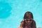 Little girl with sunglasses smiling in the swimming pool