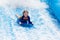 Little girl surfing in beach wave simulator