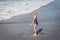 Little Girl in Swim Suit Playing in Ocean Waves at the Beach