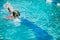 Little girl swimming during her swim lessons at the local outdoor pool in the summer