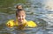 Little girl swimming in lake outdoors. Closeup