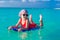 Little girl swimming on a surfboard in the turquoise sea