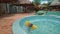 Little Girl Swims in Small Round Pool by Umbrellas at Hotel