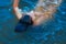 little girl swims in summer under water in the ocean, view from above