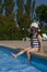 Little girl in a swimsuit and a hat plays in the pool. Rest at the hotel. Winter holidays in warm countries