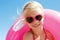 Little girl in swimsuit playing with a lifebuoy on the sea