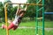 A little girl is swinging on a crossbar