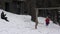 A little girl swinging on the swing while her father throws snowballs on her, 4K