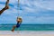 Little Girl Swings on a Rope Swing by the Beach