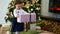 Little girl takes the big present box and gives it to her father