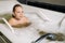 A little girl takes the procedure in a mineral bath. The patient receives water treatments with a mineral pearl bath