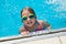 Little girl taking a break during swimming swim lessons at the local outdoor pool