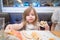 Little girl taking pizza piece with hand in restaurant