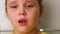 Little girl with tearful eyes speaking and exhaling soothingly closeup, white blurred background. Face of anxious child