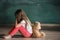 Little girl with teddy bear sitting on floor in empty room. Autism concept