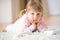 Little girl with telephone lying down on carpet