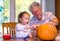 A little girl tells grandpa where she wants a pumpkin face