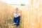 A little girl touches the hand ears of wheat in a field in summer