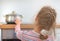 Little girl touches hot pan on the stove.