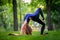 A little girl trains for yoga, does a backbend and stands on her hands in the park on the lawn